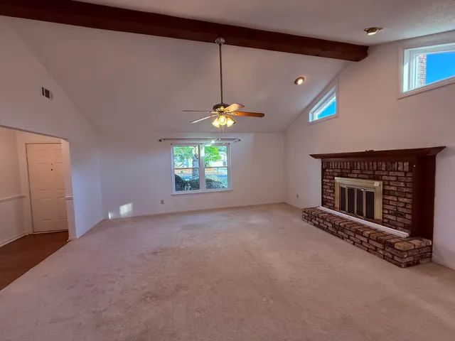 a view of empty room with a chandelier fan and windows
