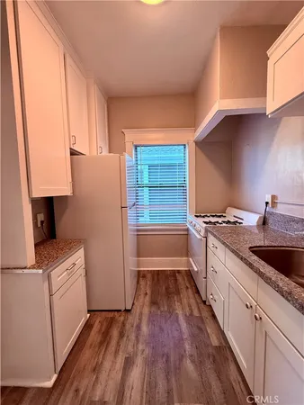 a kitchen with a sink a refrigerator and cabinets