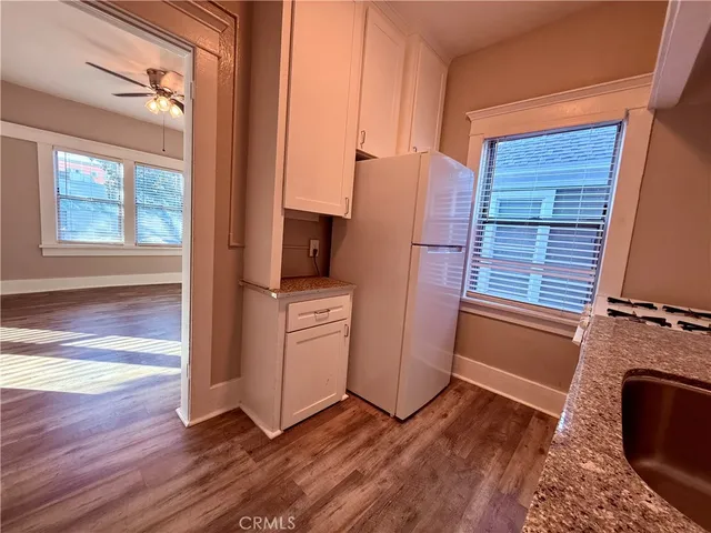 a view of a kitchen with fridge and wooden floor