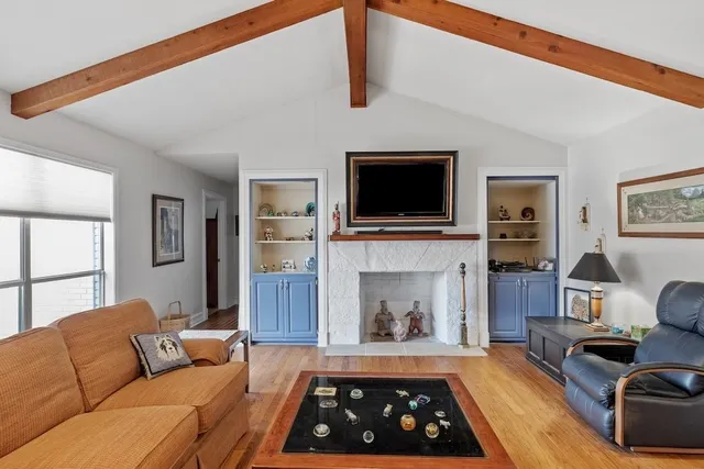 a living room with furniture wooden floor and a ceiling fan