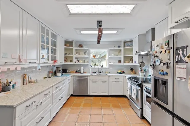 a kitchen with stainless steel appliances a stove a refrigerator and cabinets
