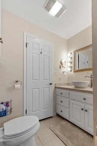 a porch with chairs and potted plant