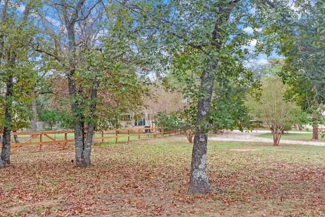 a front view of a house with a yard and trees