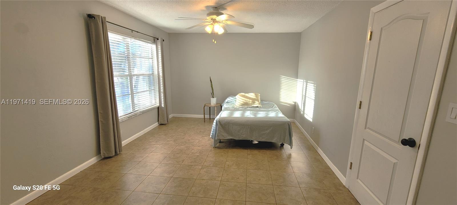 4036 Southwest 67th Terrace, Unit 5 Davie, FL 33314 - Photo 11 of 21 a spacious bedroom with a bed and a chandelier