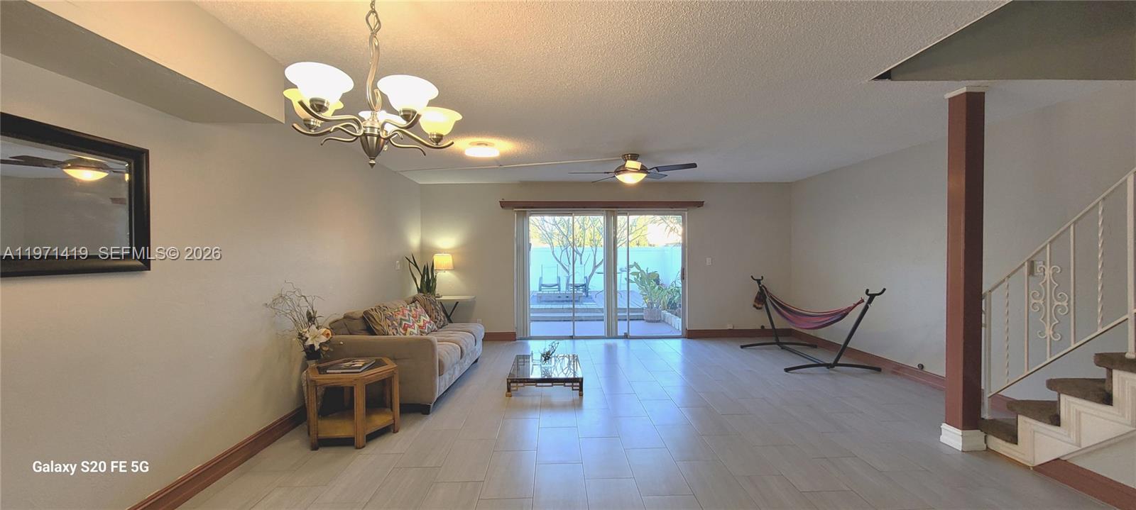 4036 Southwest 67th Terrace, Unit 5 Davie, FL 33314 - Photo 3 of 21 a living room with couches a dining table and a chandelier with wooden floor