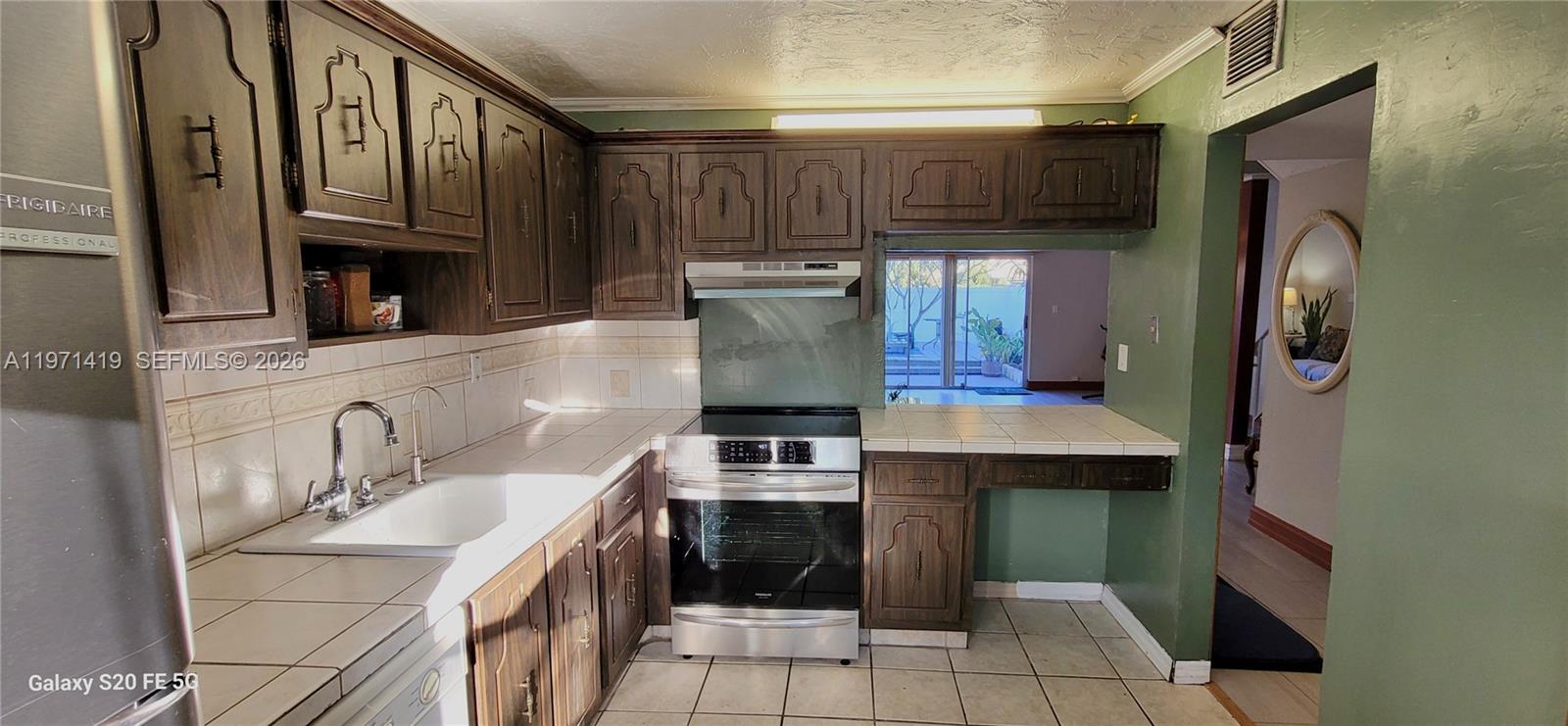 4036 Southwest 67th Terrace, Unit 5 Davie, FL 33314 - Photo 6 of 21 a kitchen with stainless steel appliances granite countertop a stove and a refrigerator