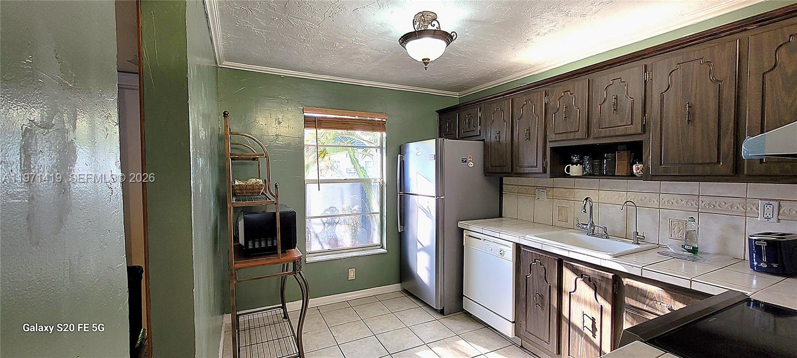 4036 Southwest 67th Terrace, Unit 5 Davie, FL 33314 - Photo 7 of 21 a kitchen with refrigerator and cabinets