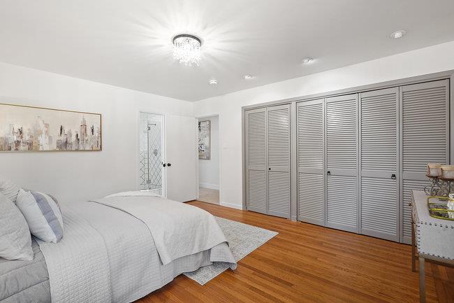 3324 Woodside Road Woodside, CA 94062 - Photo 19 of 60 a spacious bedroom with a bed and a painting on the wall