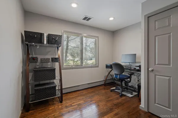 a view of workspace room with wooden floor cabinet and windows