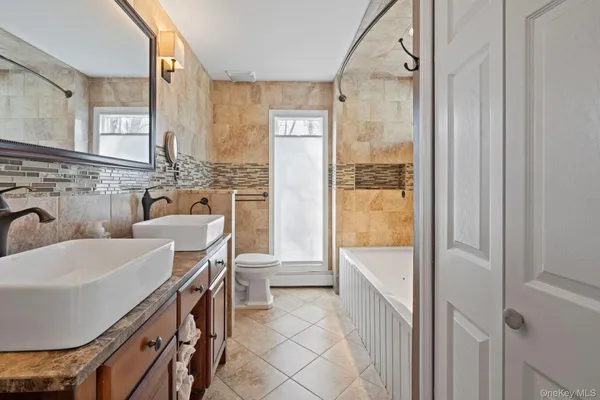 a bathroom with a granite countertop sink a toilet and tub