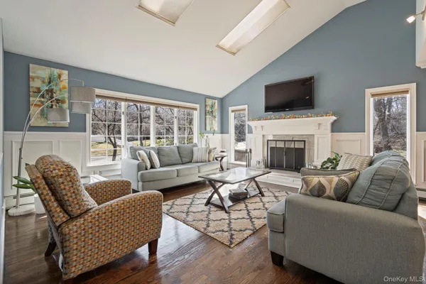a living room with furniture a flat screen tv and a fireplace