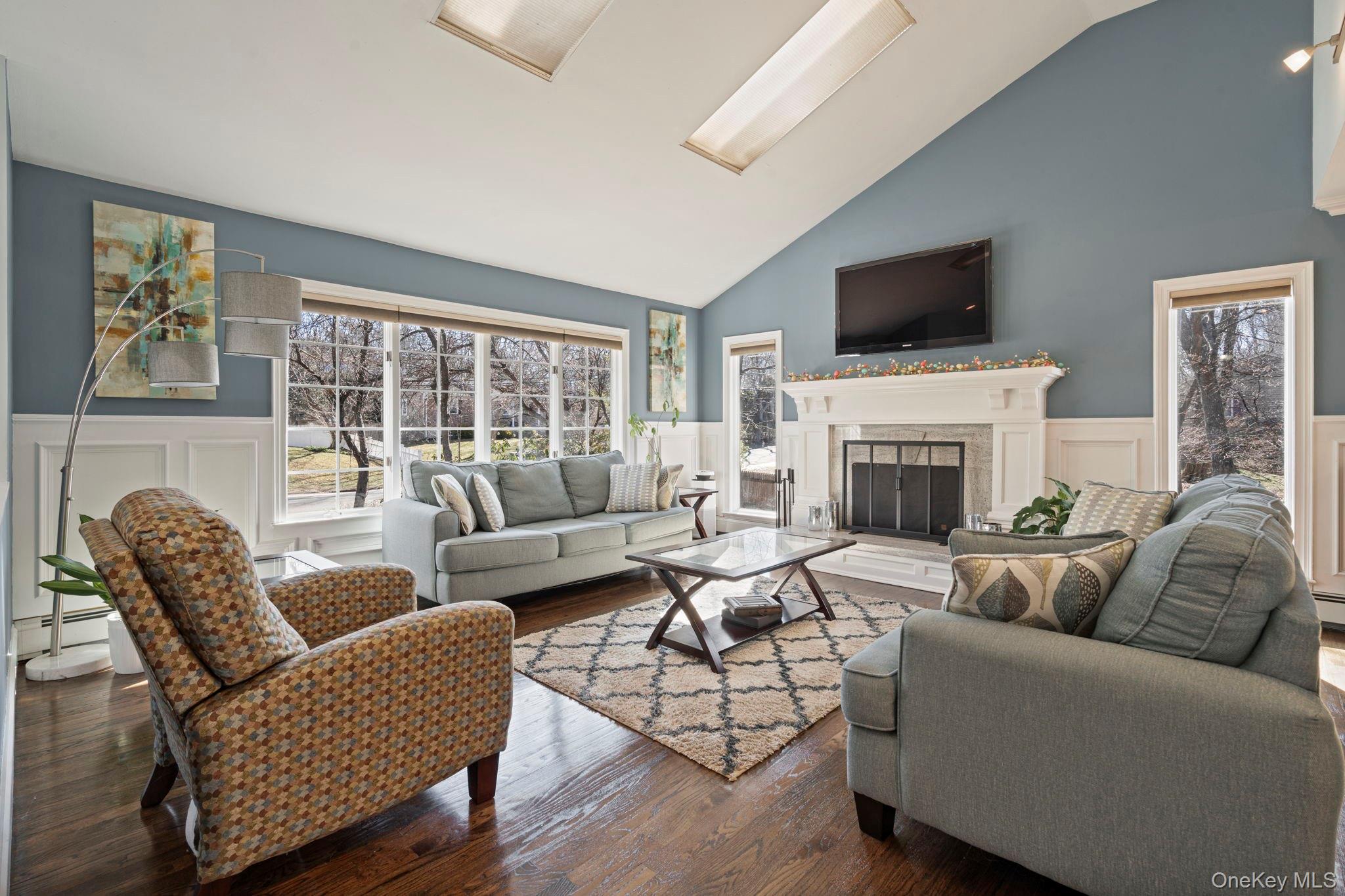 25 Cliff Road West Wading River, NY 11792 - Photo 3 of 35 a living room with furniture a flat screen tv and a fireplace