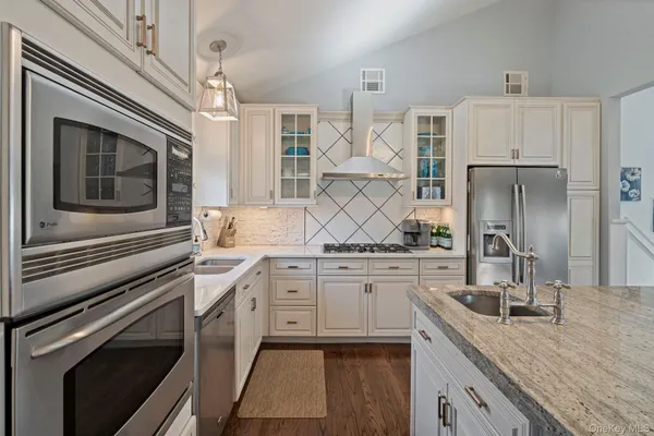 a kitchen with granite countertop a sink stainless steel appliances and cabinets
