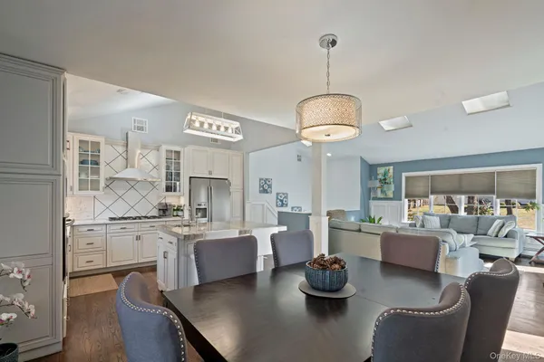 a kitchen with stainless steel appliances kitchen island granite countertop a table and chairs in it