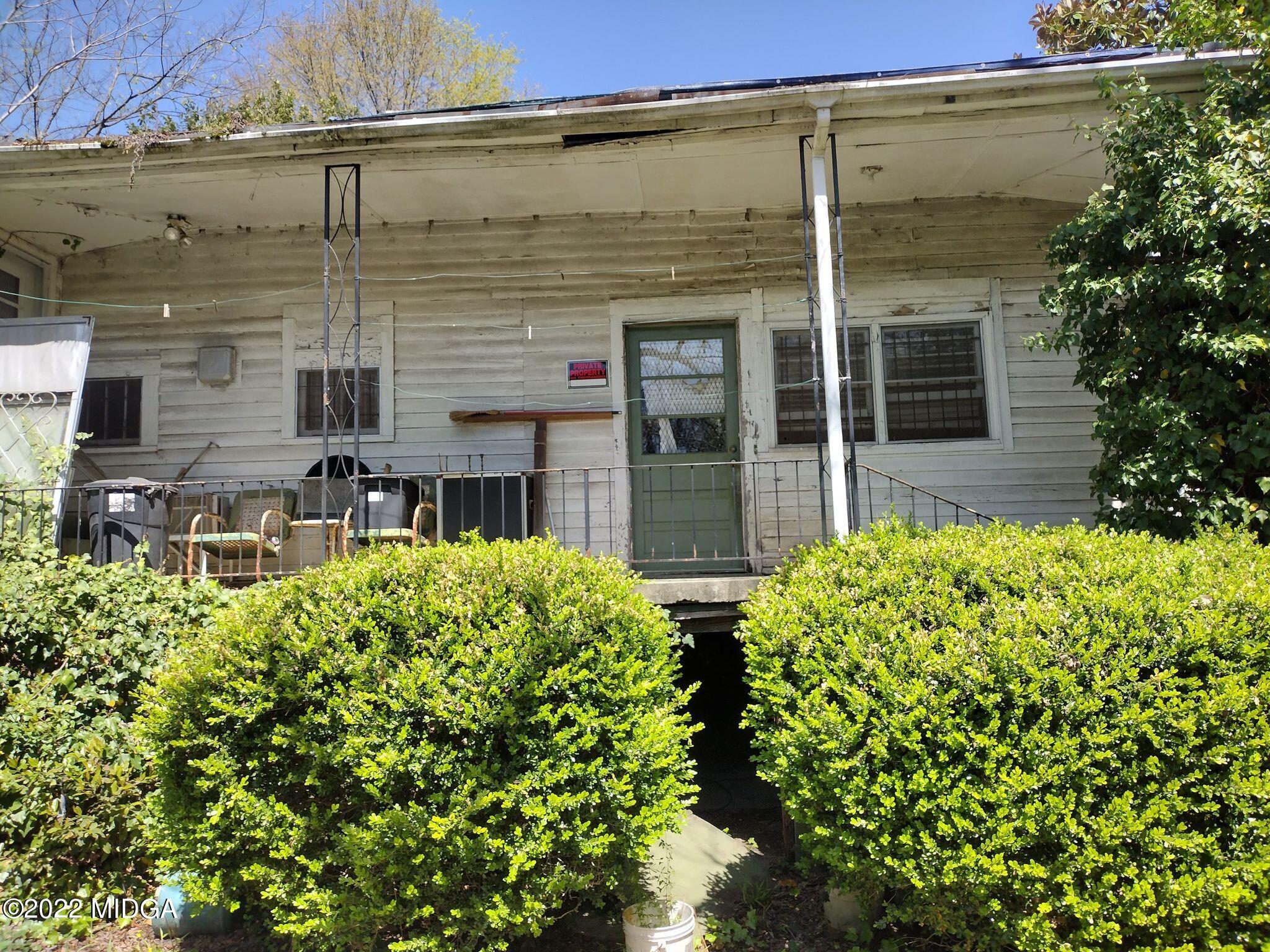 front view of a house with a large window and potted plants