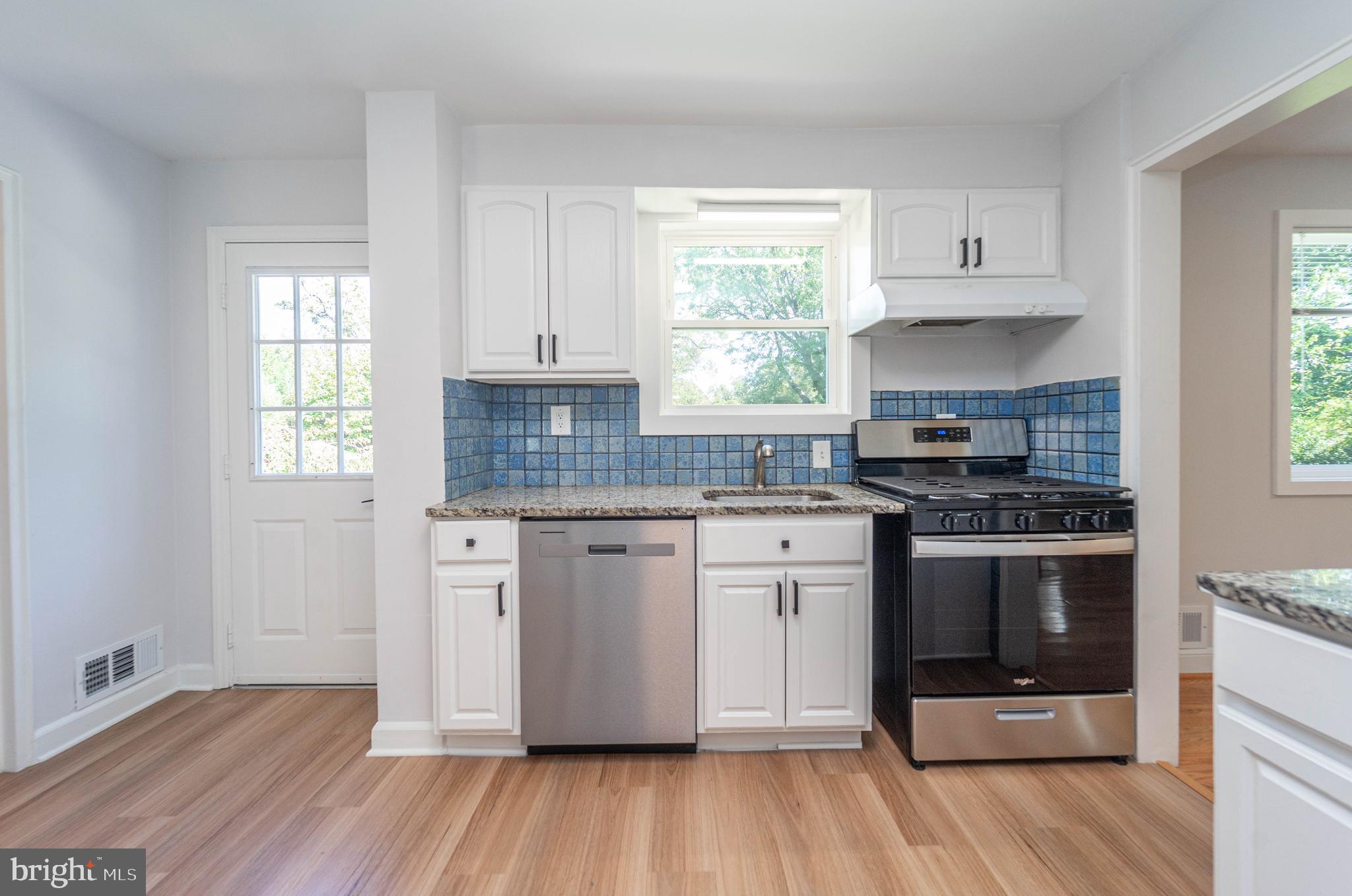 8909 Georgia Avenue Silver Spring, MD 20910 - Photo 18 of 47 a kitchen with granite countertop wooden floors and white stainless steel appliances