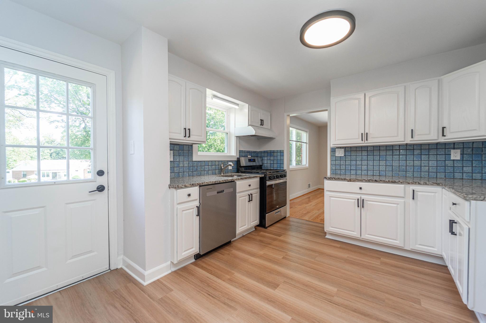 8909 Georgia Avenue Silver Spring, MD 20910 - Photo 19 of 47 a kitchen with granite countertop white cabinets a appliances a sink and a window