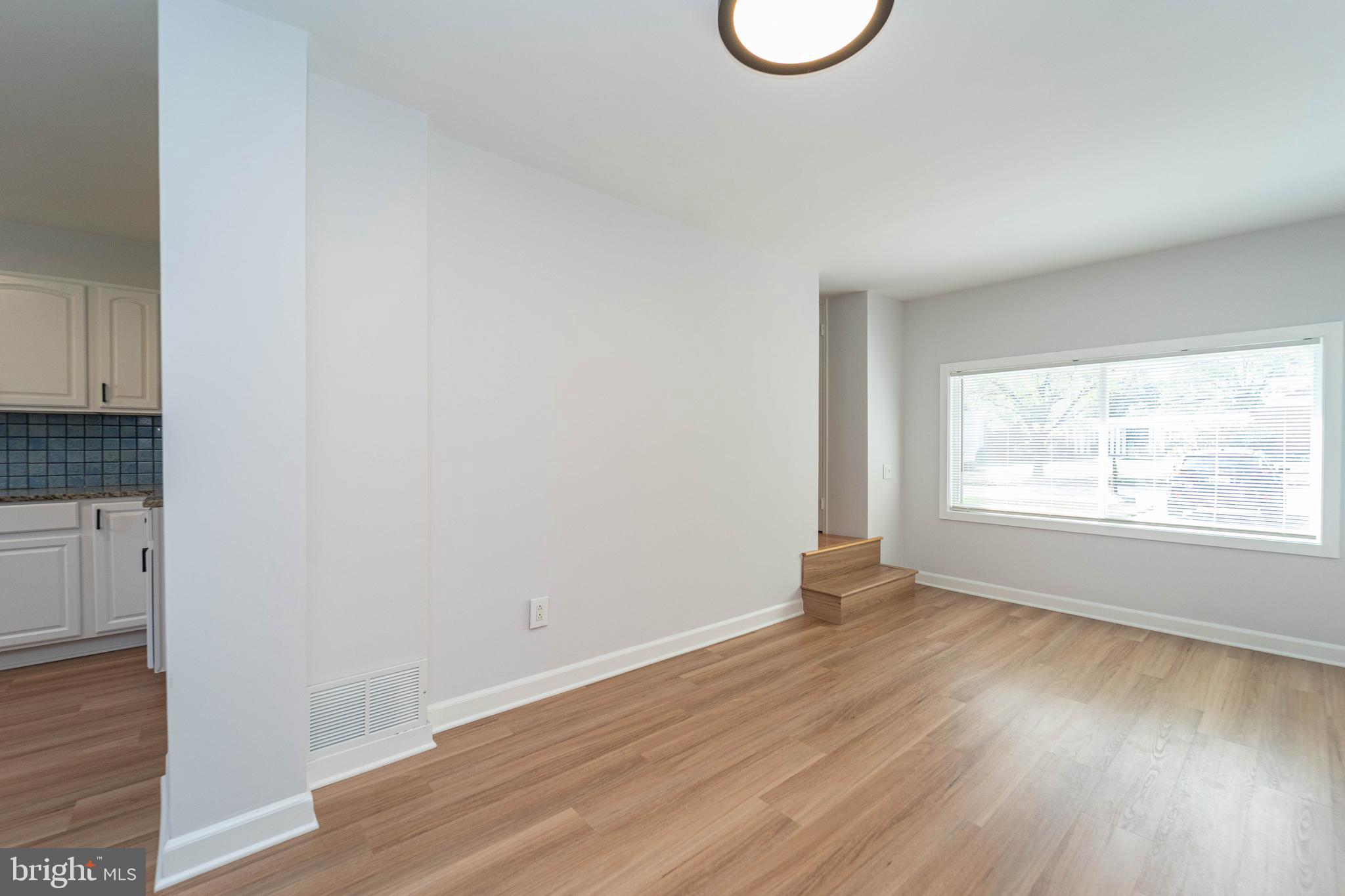 8909 Georgia Avenue Silver Spring, MD 20910 - Photo 23 of 47 a view of an empty room with wooden floor and a window