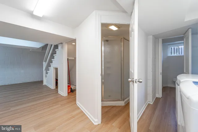 a view of a hallway with a room and wooden floor