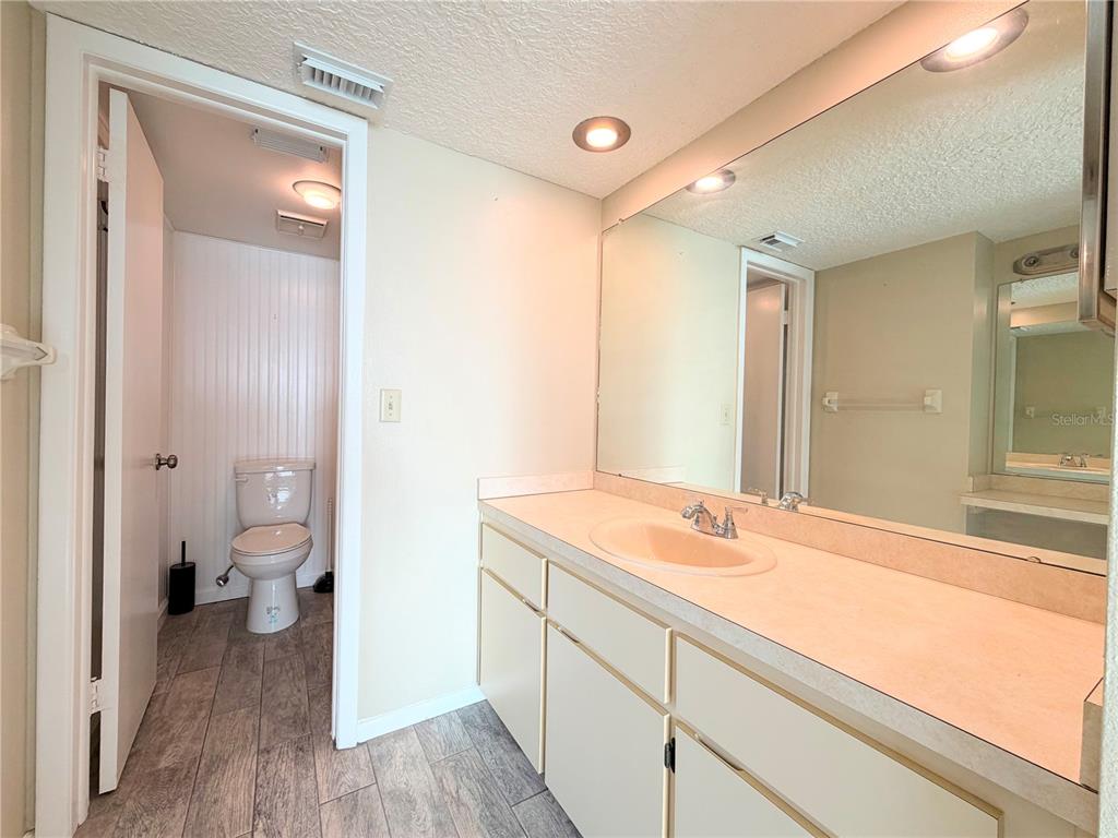 4550 Bay Boulevard, Unit 1224 Port Richey, FL 34668 - Photo 17 of 25 a bathroom with a sink a toilet and a large mirror