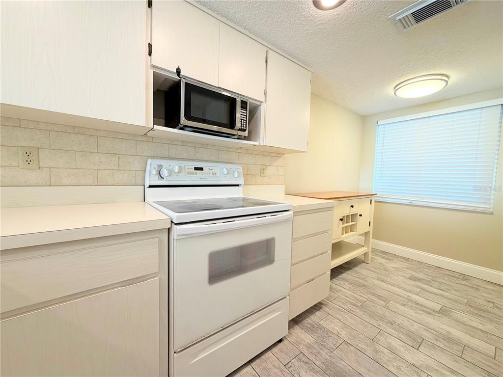 4550 Bay Boulevard, Unit 1224 Port Richey, FL 34668 - Photo 10 of 25 a kitchen with a stove and a microwave