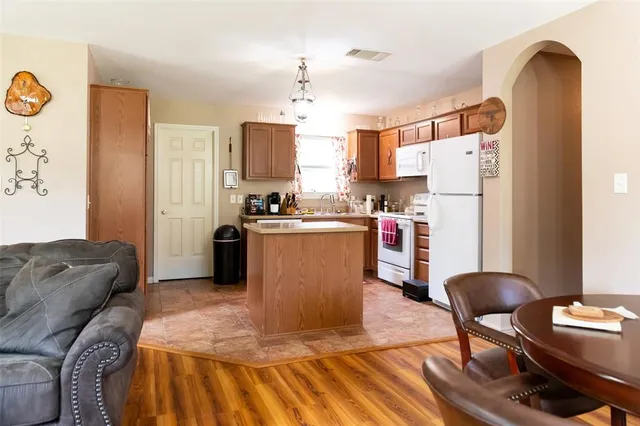 a living room with stainless steel appliances kitchen island granite countertop furniture and a refrigerator
