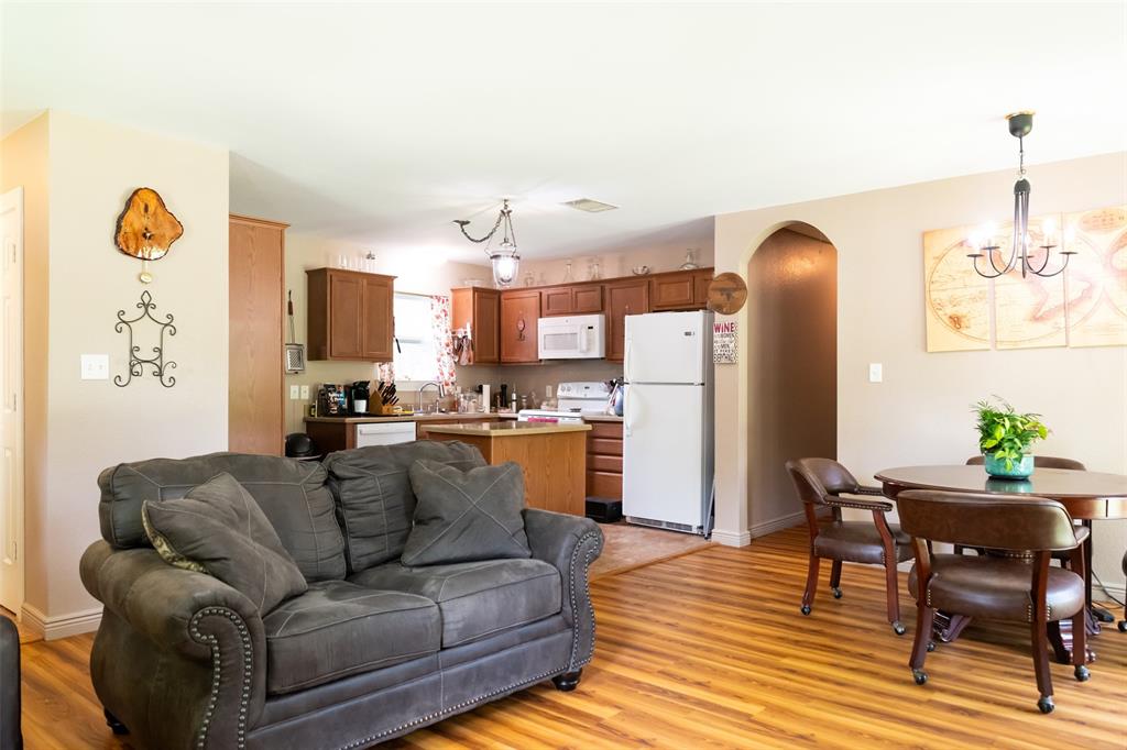 1019 Pine Street Bonham, TX 75418 - Photo 18 of 26 a living room with furniture a refrigerator and a dining table