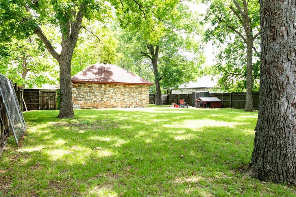 1019 Pine Street Bonham, TX 75418 - Photo 23 of 26 a view of a house with backyard and a tree