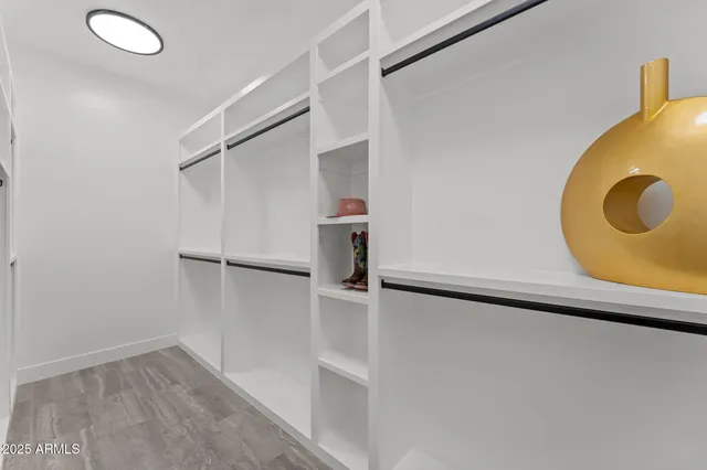 an empty room with wooden floor and mirror