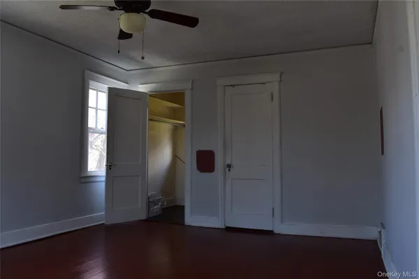 an empty room with a window and wooden floor