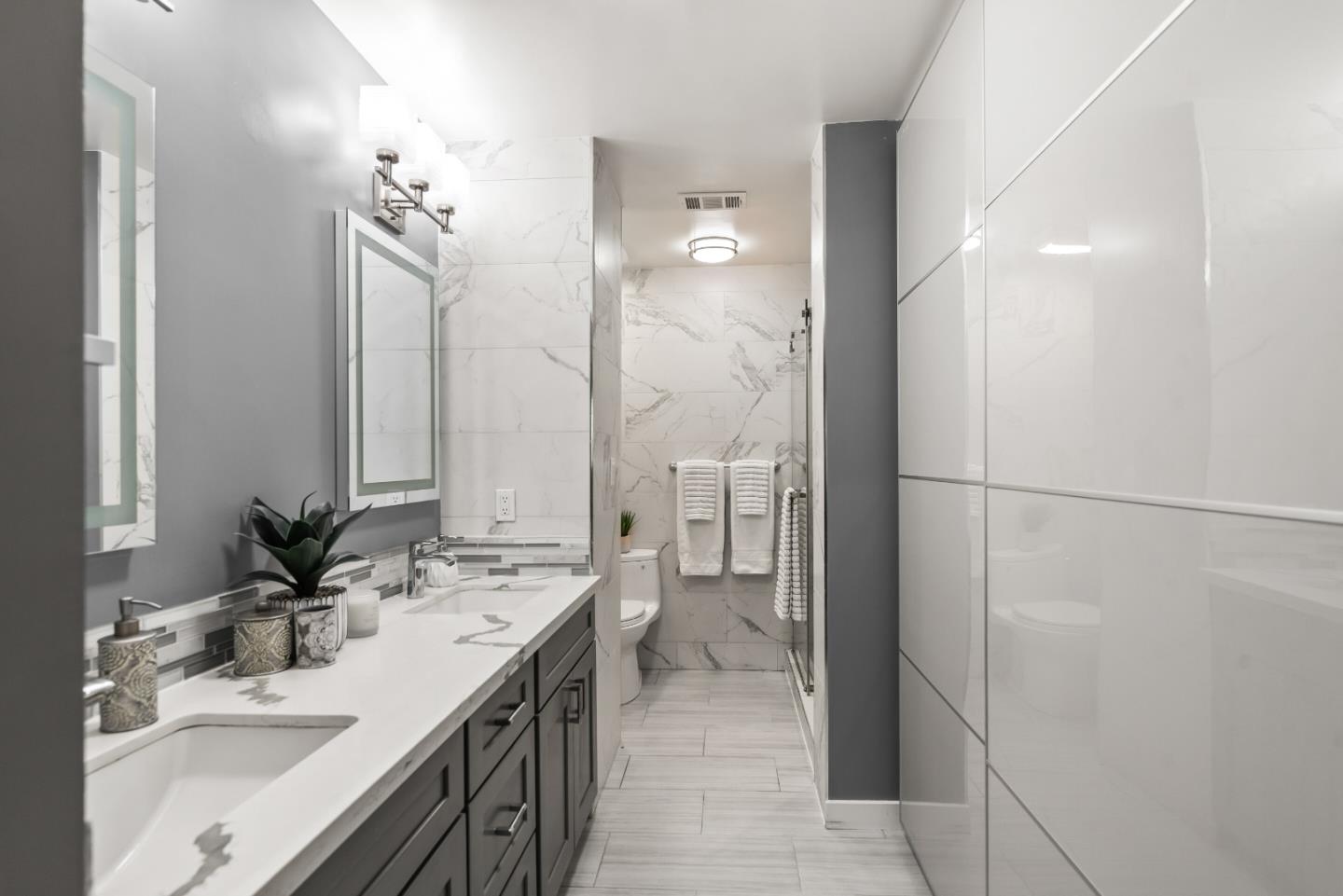 22873 Longdown Road Cupertino, CA 95014 - Photo 30 of 43 a bathroom with a double vanity sink a mirror and a shower