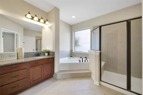 a spacious bathroom with a tub a sink and mirror