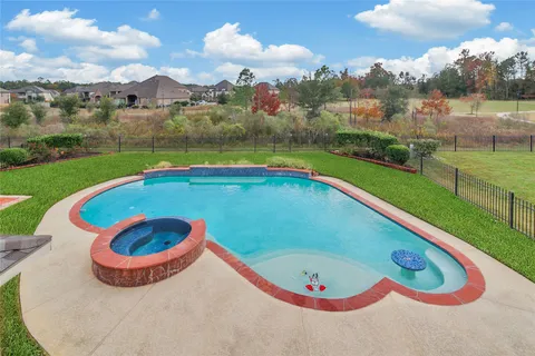 a view of a swimming pool with a yard and plants