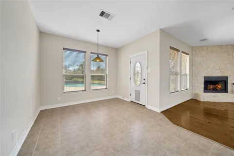 an empty room with windows and fireplace