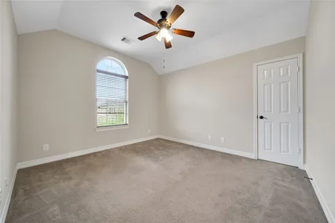 an empty room with windows and fan