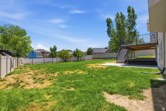 1252 Skyline Road Saratoga Springs, UT 84045 - Photo 48 of 51 Expansive rear yard featuring a large lawn area, a multi-level deck with black railings, and a concrete patio