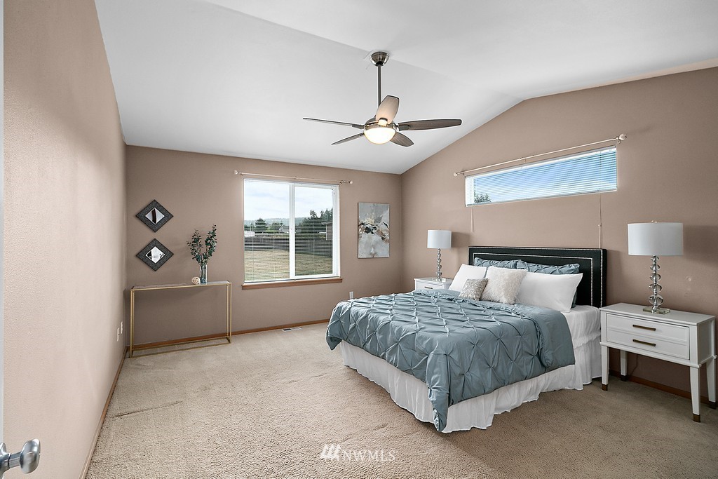 18210 Joseph Drive Southwest Rochester, WA 98579 - Photo 22 of 39 a bedroom with a large bed and a chandelier