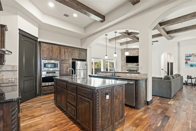 a kitchen with stainless steel appliances granite countertop a sink and stove