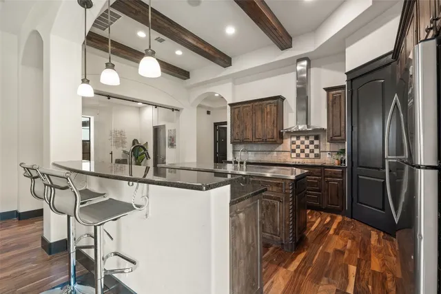 a kitchen with stainless steel appliances granite countertop a sink a stove and a wooden floors