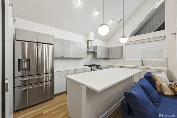 a kitchen with stainless steel appliances granite countertop a sink a stove a refrigerator cabinets and a stove