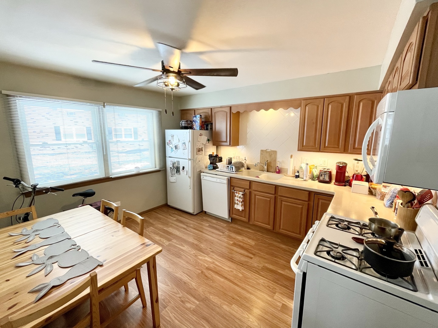 8804 45th Place, Unit 3 Brookfield, IL 60513 - Photo 6 of 9 a kitchen with a stove a sink dishwasher and a dining table with wooden floor