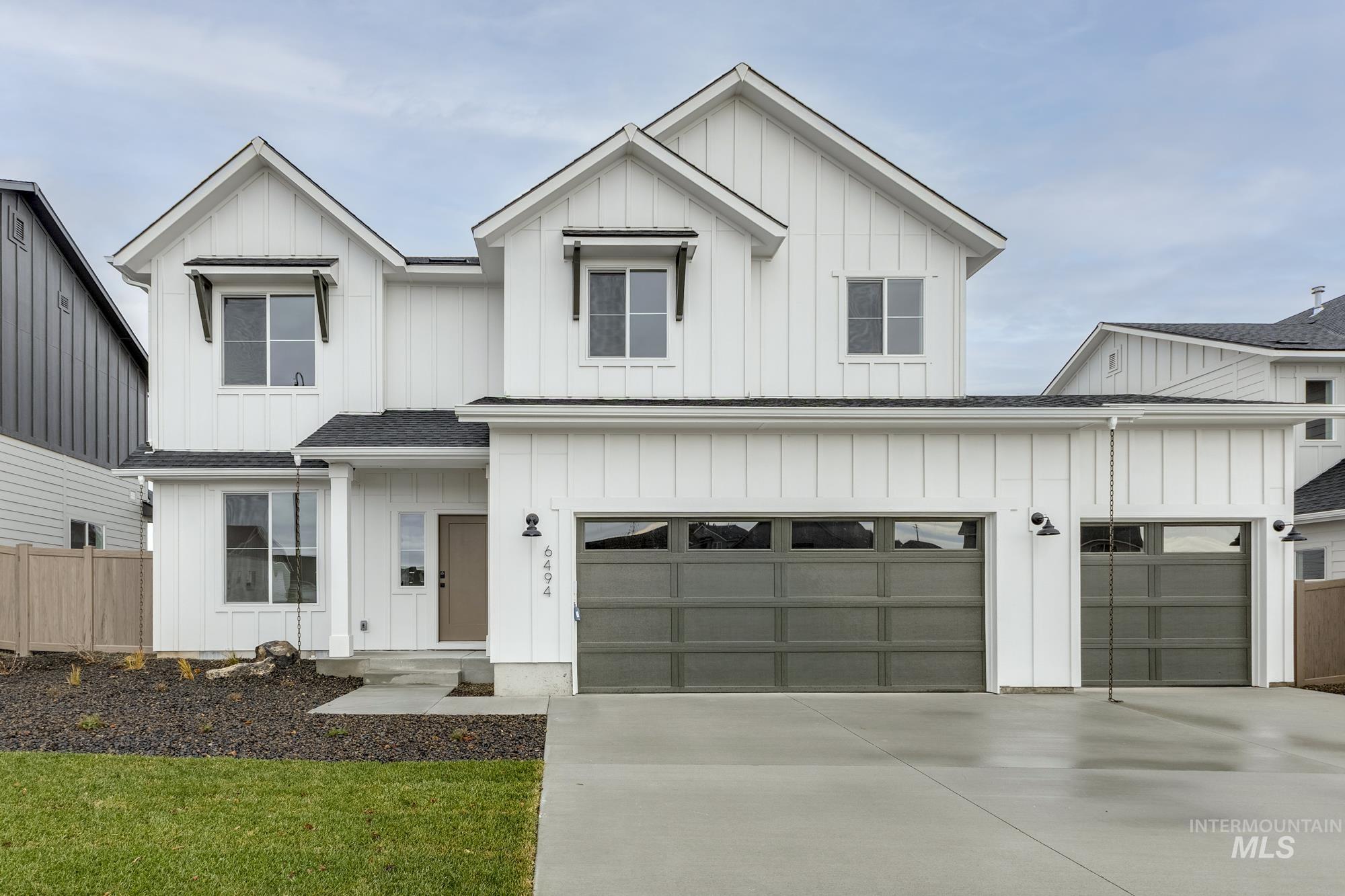 Modern inspired farmhouse featuring board and batten siding, concrete driveway, and a shingled roof