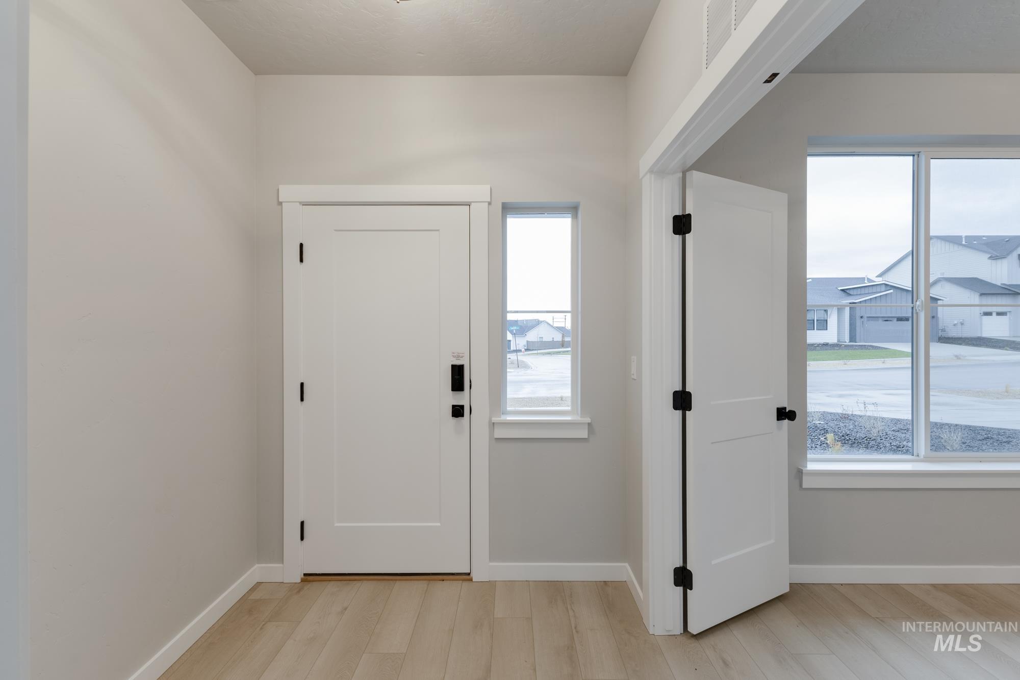 6494 South Sunfish Avenue Boise, ID 83709 - Photo 10 of 32 Entryway featuring baseboards and light wood-style floors