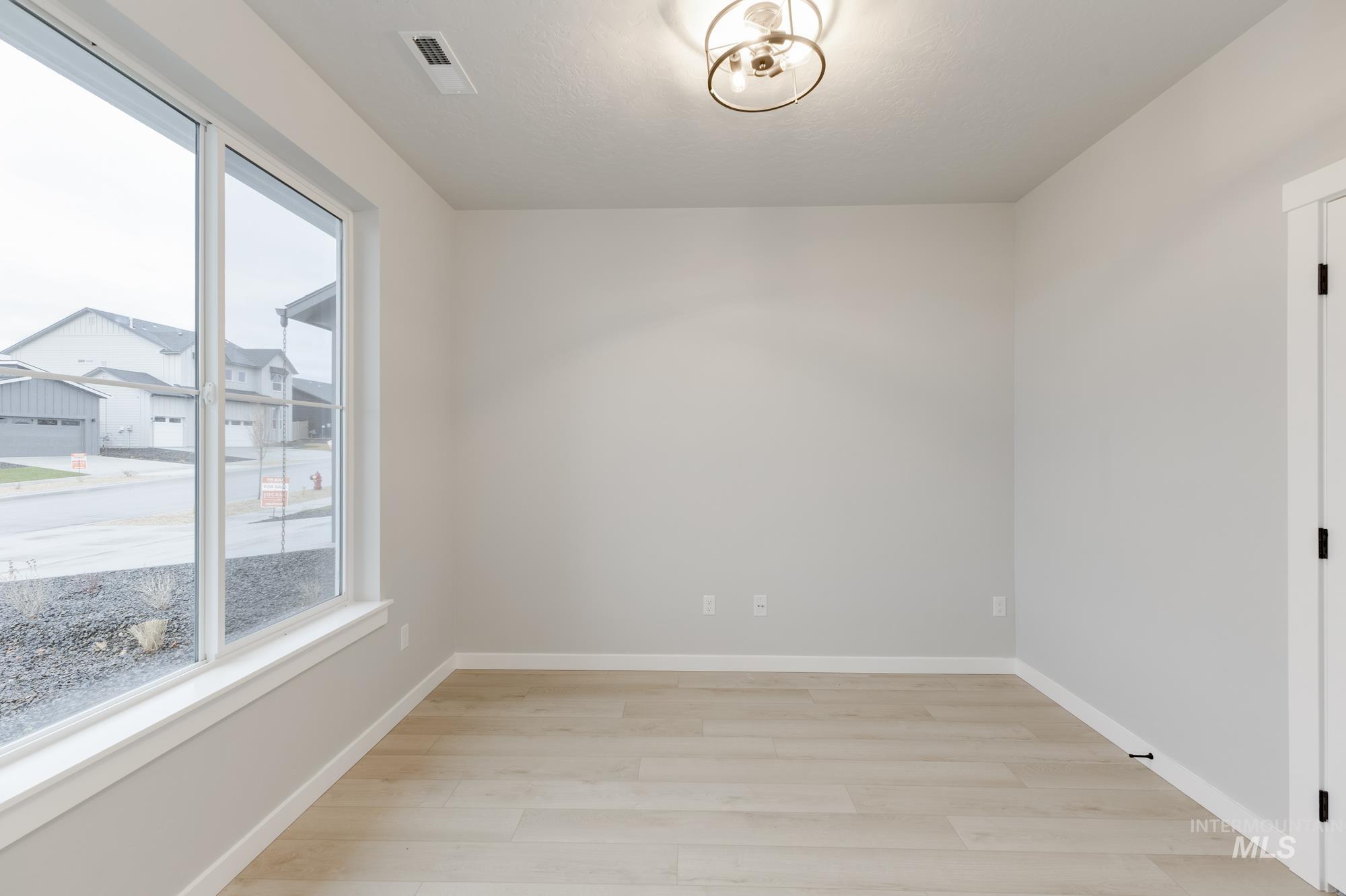 6494 South Sunfish Avenue Boise, ID 83709 - Photo 11 of 32 Spare room featuring baseboards and light wood-style floors