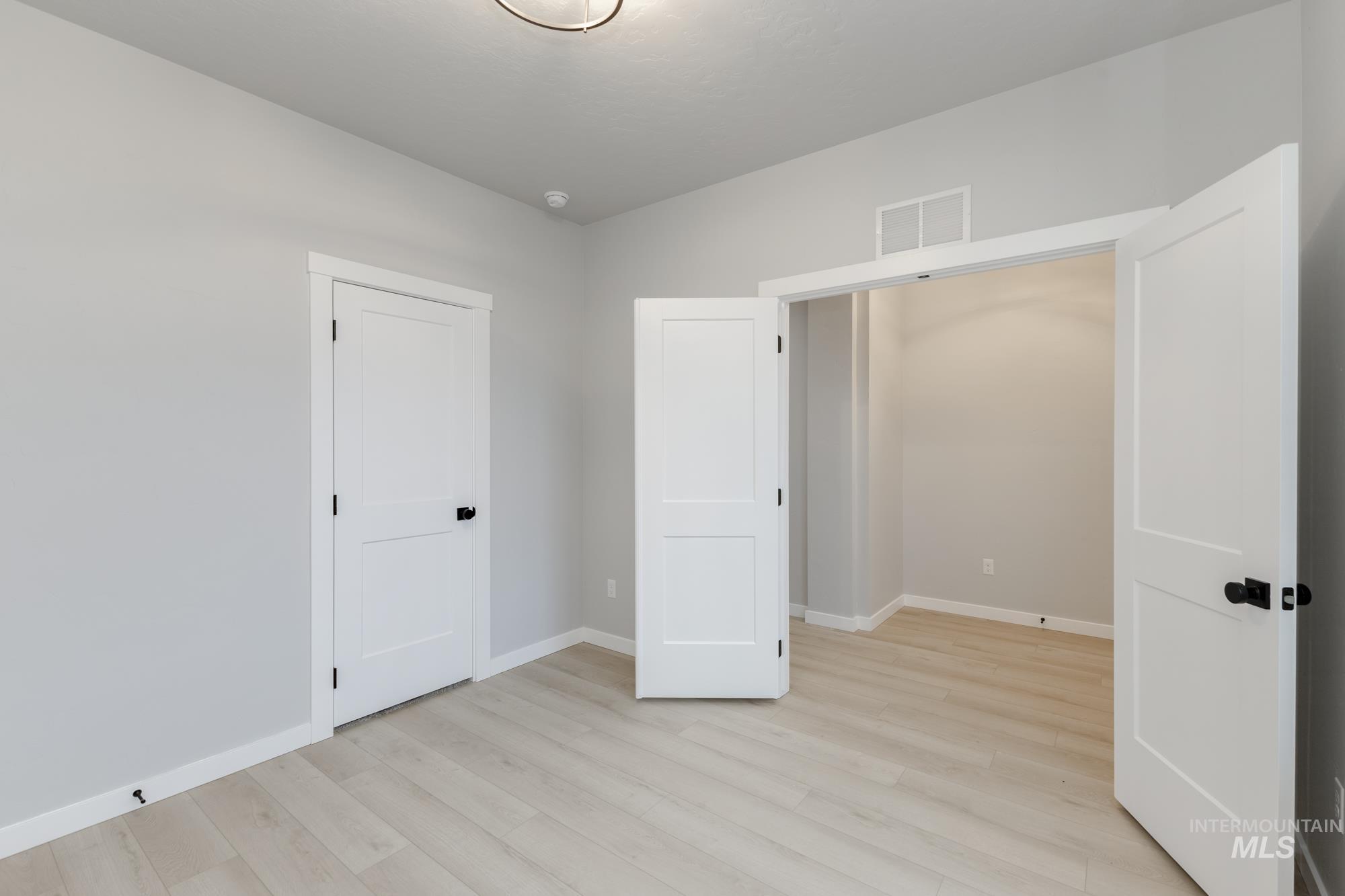 6494 South Sunfish Avenue Boise, ID 83709 - Photo 12 of 32 Unfurnished bedroom with baseboards and light wood-style flooring