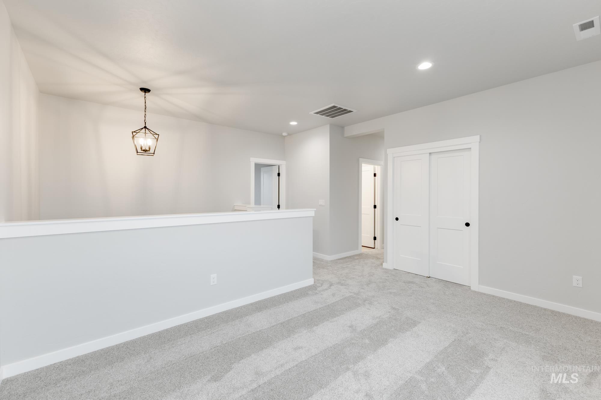 6494 South Sunfish Avenue Boise, ID 83709 - Photo 16 of 32 Spare room with recessed lighting, light carpet, and a chandelier