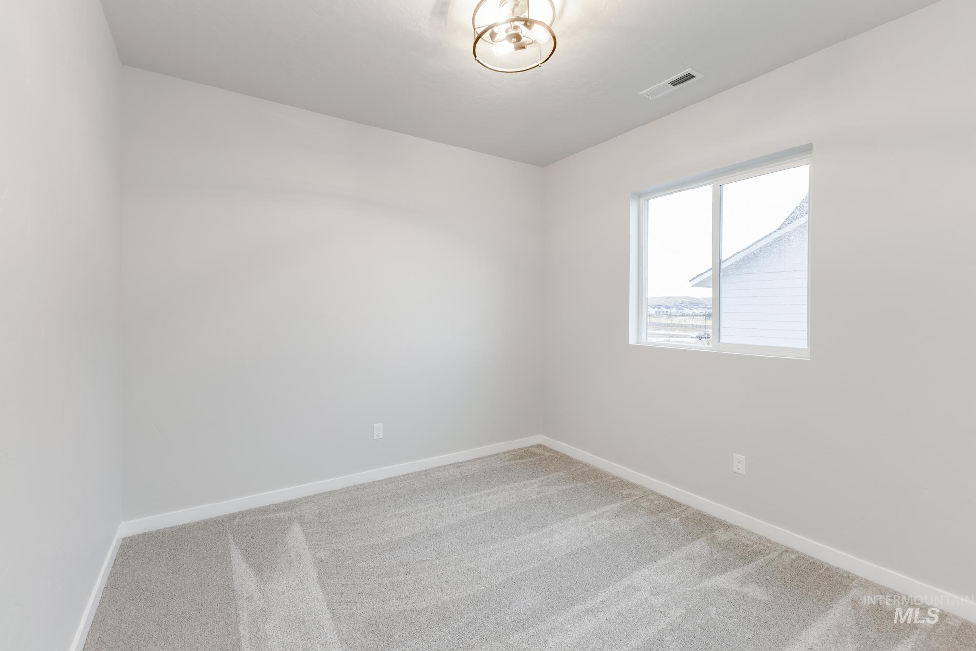 6494 South Sunfish Avenue Boise, ID 83709 - Photo 20 of 32 Empty room featuring light carpet and baseboards
