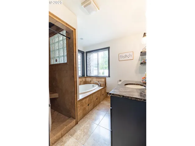 a bathroom with a tub sink and mirror