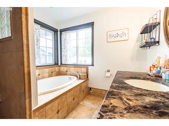 a bathroom with a tub sink and a window