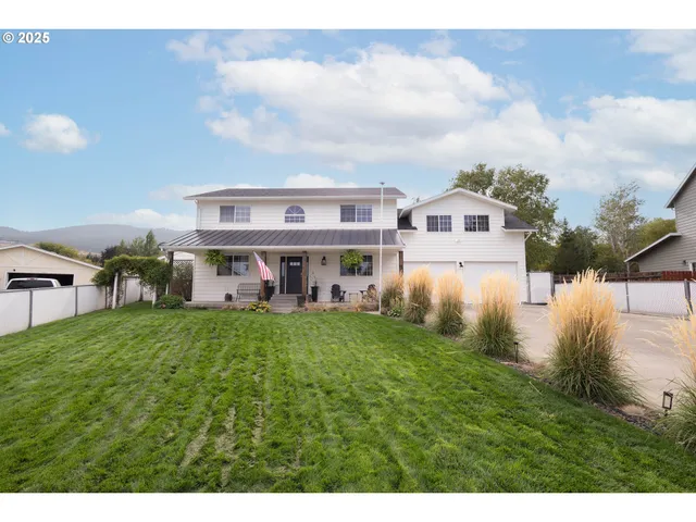 a view of house with garden and tall trees